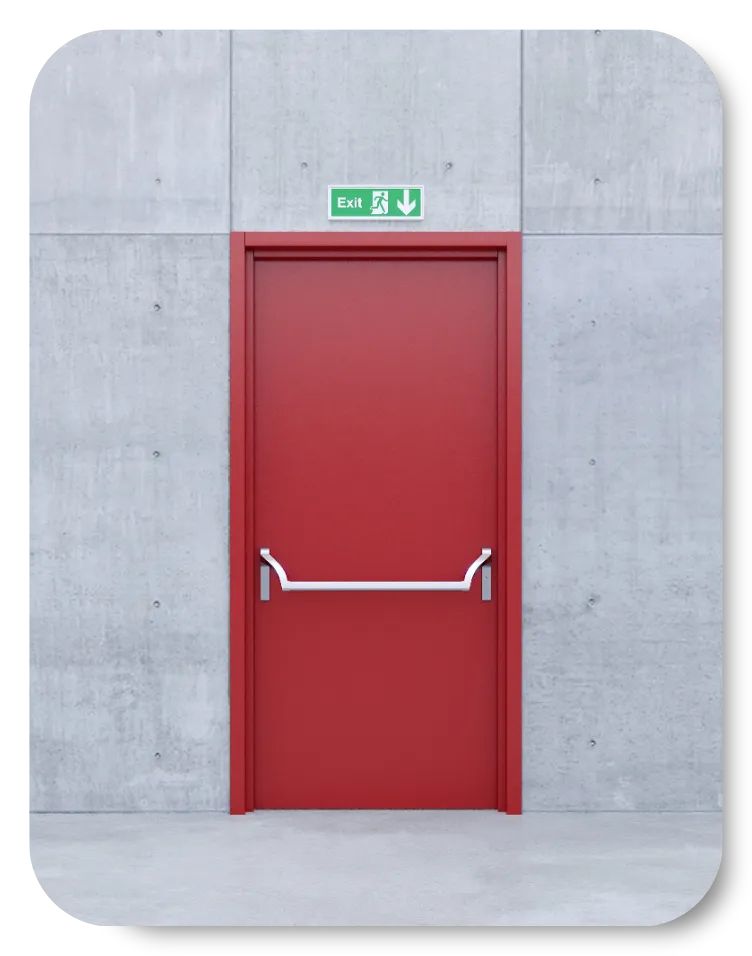 Red emergency exit door with a horizontal push bar and green illuminated exit sign mounted on a concrete wall.