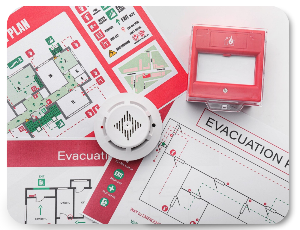 Emergency evacuation plans and fire safety equipment, including a smoke detector and a manual fire alarm call point, displayed on top of floor maps.