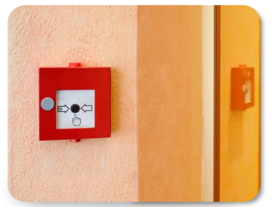 Red fire alarm break glass unit mounted on wall for emergency use